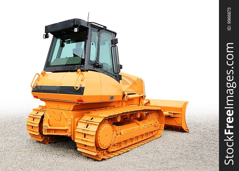 Yellow bulldozer over a grey gravel