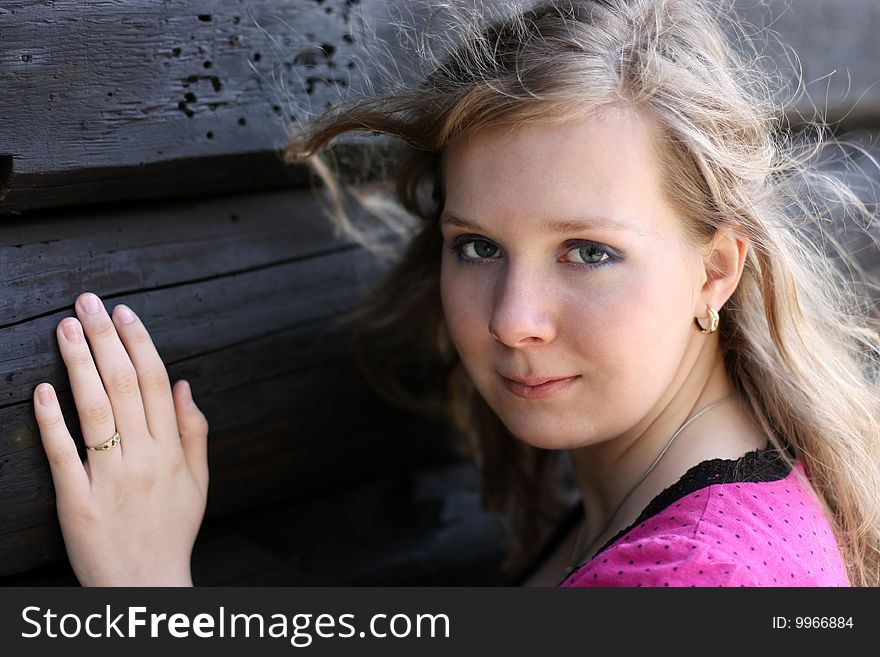 Young girl in front of wooden log hut