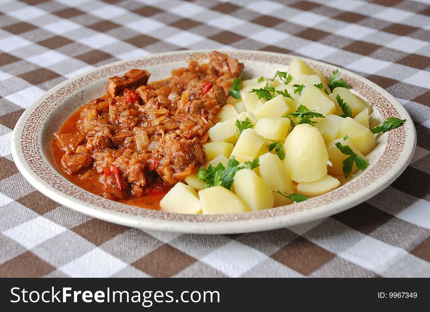 Goulash with new potatoes on a plate. Hungarian food