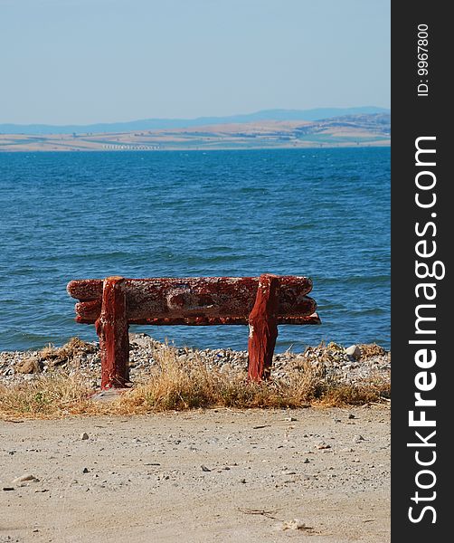 A stone made alone bench standing by the beach. A stone made alone bench standing by the beach