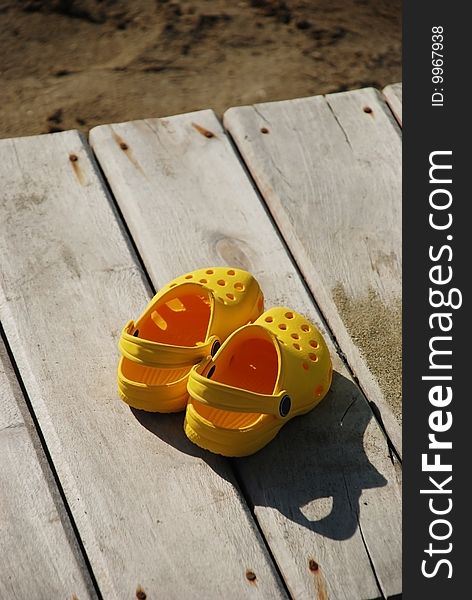 Kid sandals on wooden plate
