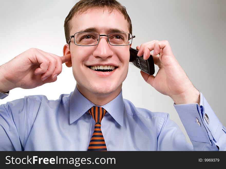 Funny looking handsome businessman talking on cellphone. Funny looking handsome businessman talking on cellphone