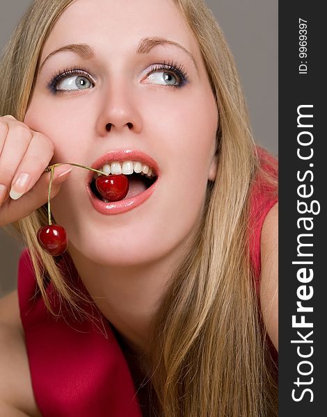 Healthy young woman eating red cherries