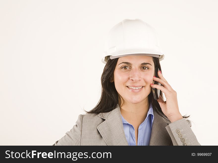 Professional woman using mobile phone wearing hard hat. Professional woman using mobile phone wearing hard hat