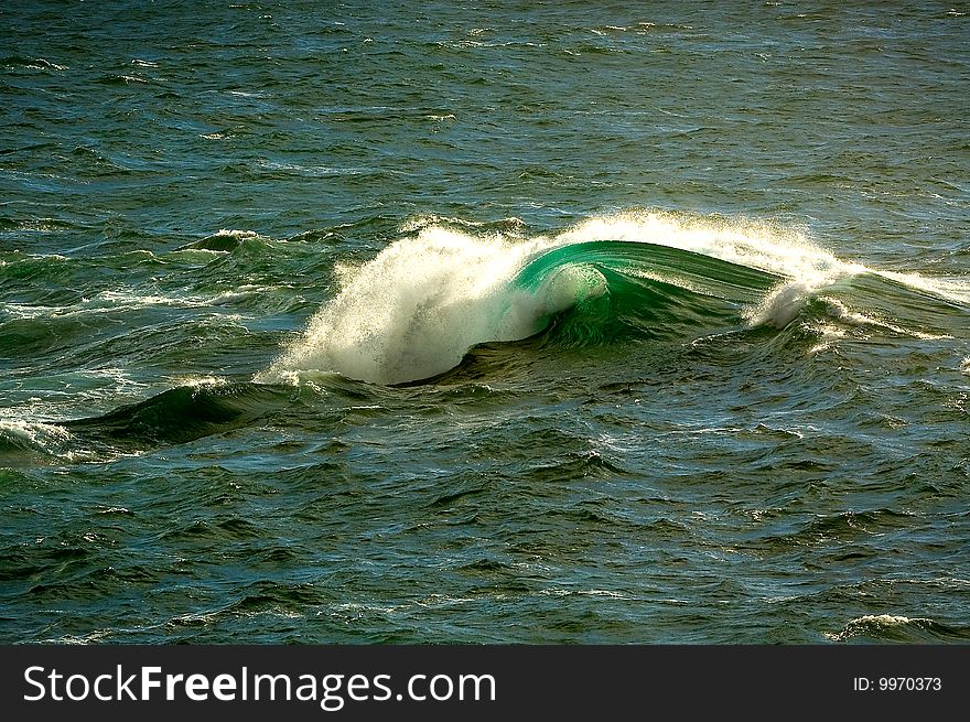 Single wave breaking offshore surrounded by open water