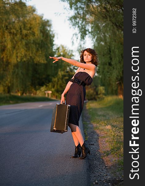 Young woman waitin a car from the roadside