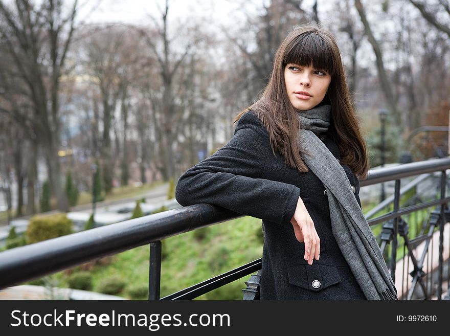 Spring, young woman stay lean on the bridge railing