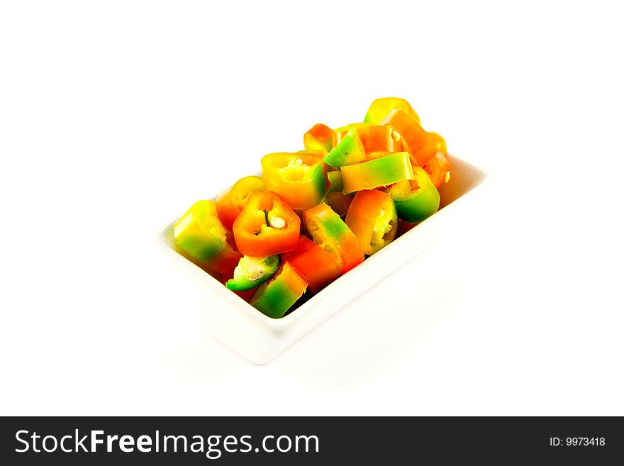 Red, yellow and green chillis chopped in a dish with clipping path on a white background. Red, yellow and green chillis chopped in a dish with clipping path on a white background