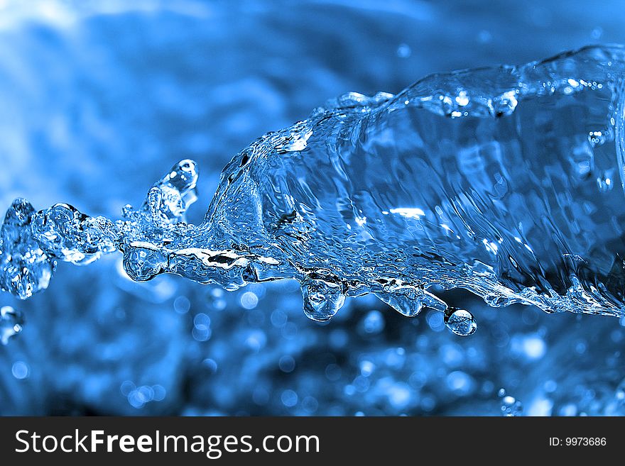 The shot of water splashing and blue drops. The shot of water splashing and blue drops