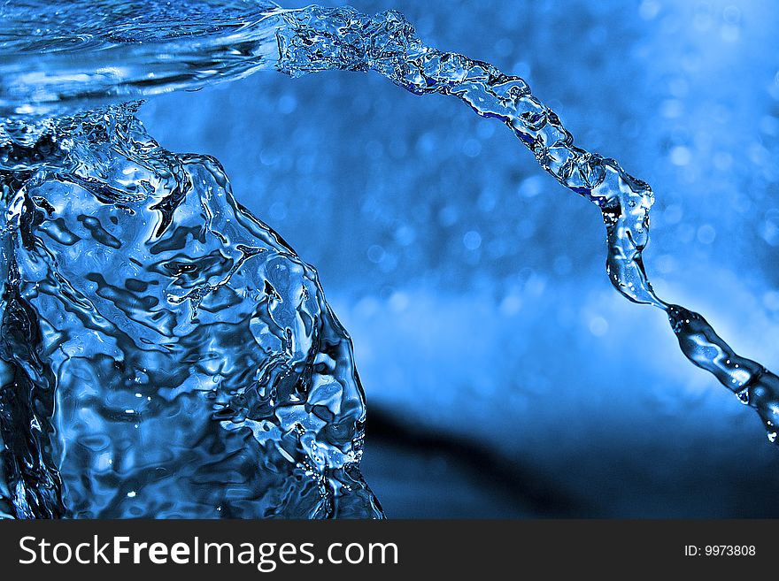 The shot of water splashing and blue drops. The shot of water splashing and blue drops