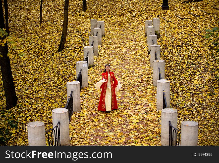 Lady in medieval red dress in the autumn forest. Lady in medieval red dress in the autumn forest