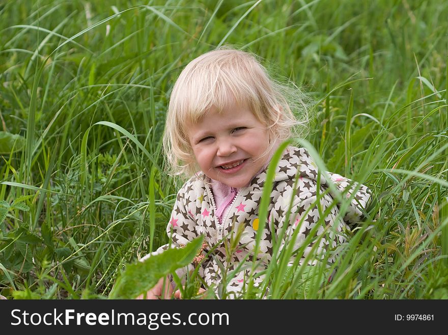 Beautiful girl is sitting in a field of grass. Beautiful girl is sitting in a field of grass