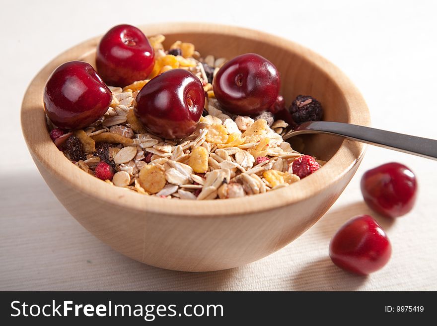 Muesli with fresh cherry in wooden bowl. Muesli with fresh cherry in wooden bowl