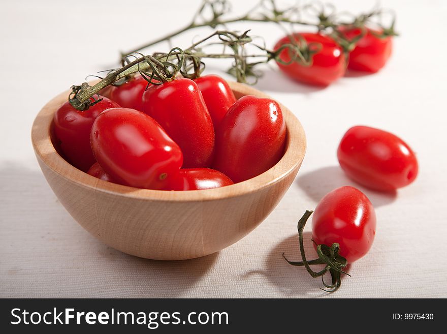 Red ripe tomatoes in wooden bowl
