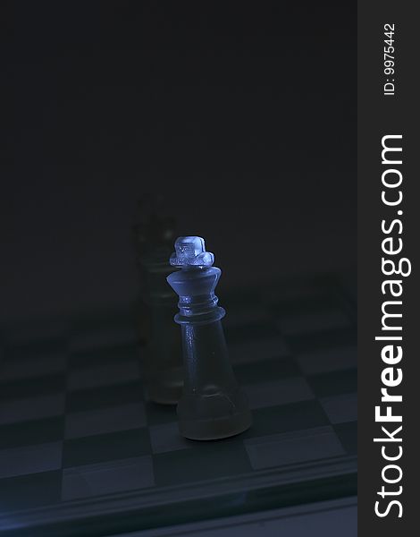 Transparent chess glowing in the dark focusing on king