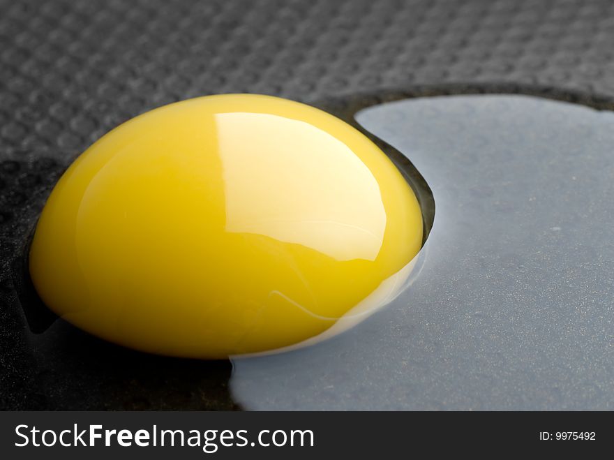 Broken egg in a black pan