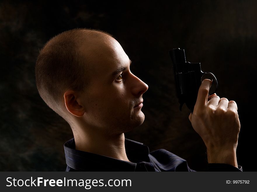 Man with a gun. Dark background.