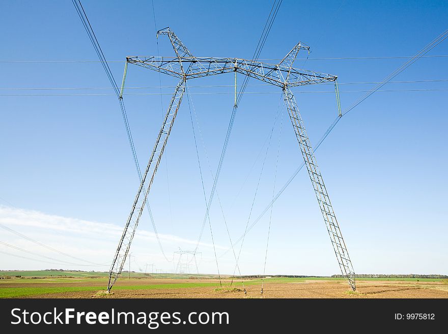 High voltage pylons on the background  of  blue  cloudless  sky