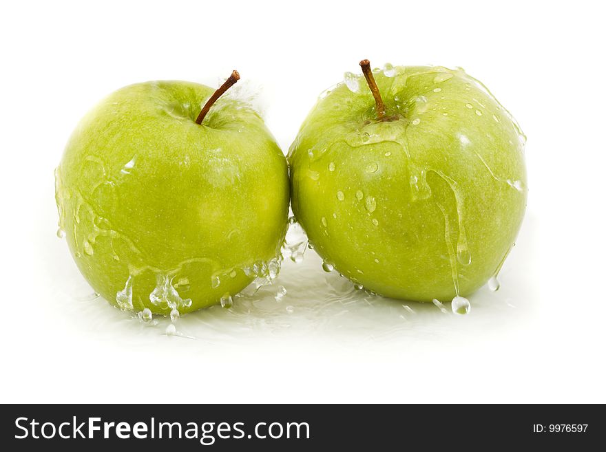 Two green apples with droplets on a white background