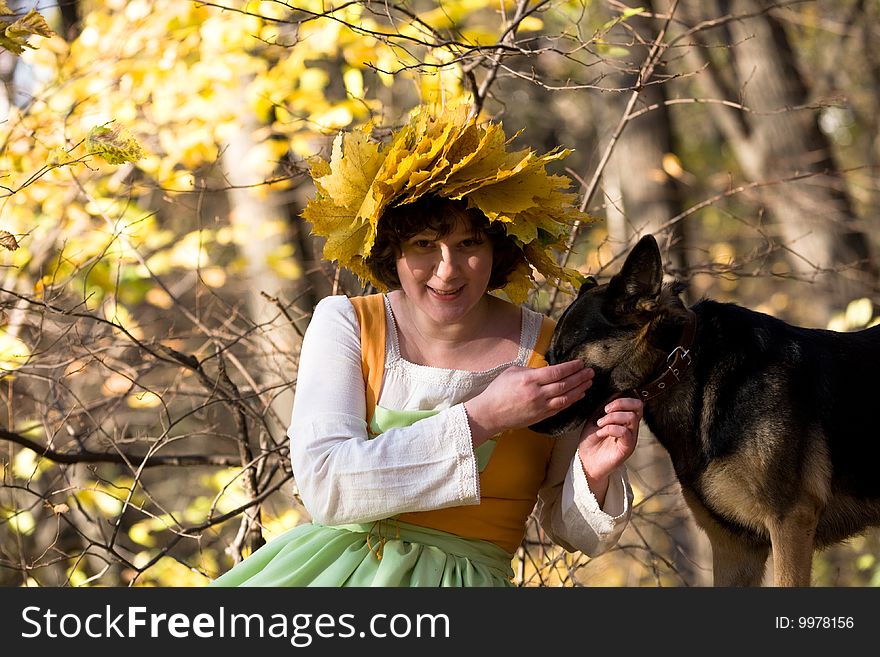 Woman and dog in autumn forest