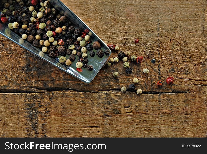 Colorful peppercorns on a rustic wood table. Colorful peppercorns on a rustic wood table.