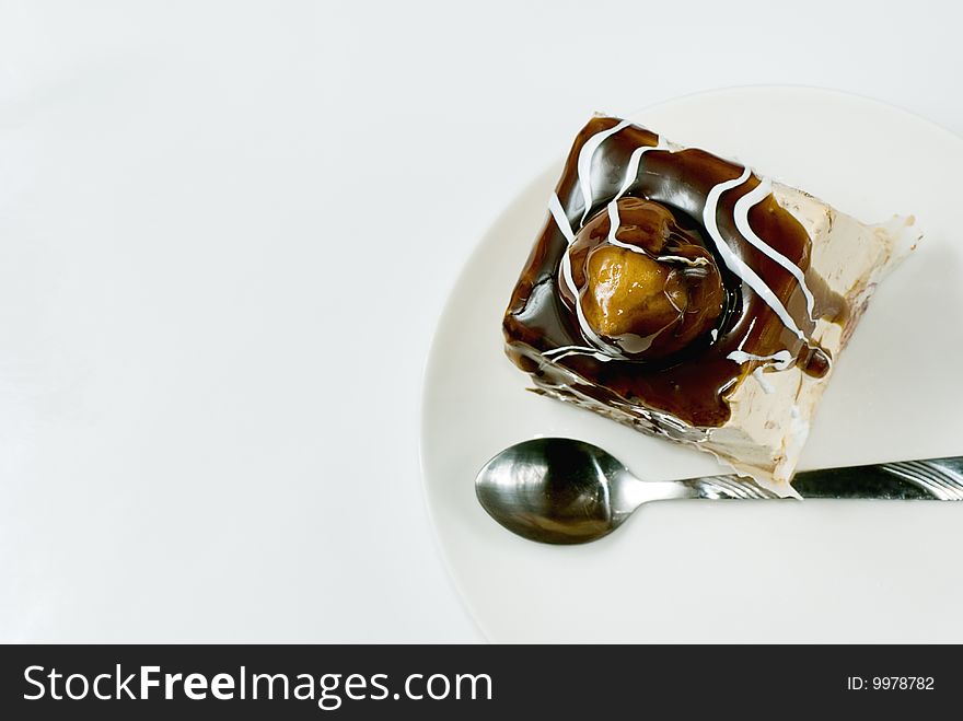 Profiterole covered with chocolate syrup on white plate. Profiterole covered with chocolate syrup on white plate