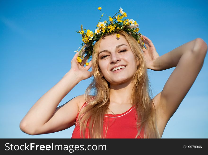 A portrait of pretty girl in a chaplet of summer flowers. A portrait of pretty girl in a chaplet of summer flowers