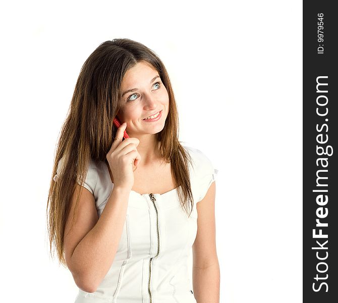 A smiling beautiful young woman in a white dress speaking by mobile phone. A smiling beautiful young woman in a white dress speaking by mobile phone