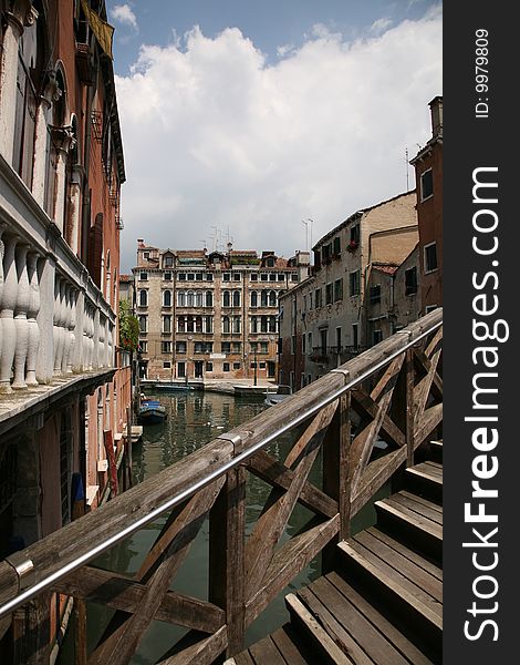 View in Venice : wooden bridge, channel, houses, boat. View in Venice : wooden bridge, channel, houses, boat