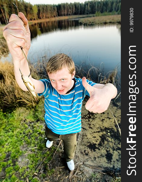 A cute guy showing a fish. A cute guy showing a fish