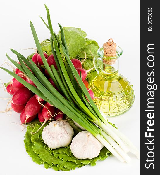 Green vegetables and a bottle of olive oil on the white background. Green vegetables and a bottle of olive oil on the white background