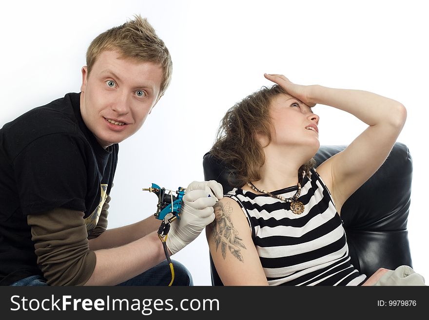 An image of a man making tattoo a shoulder of woman. An image of a man making tattoo a shoulder of woman