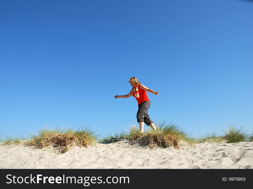 Mature woman about to jump along the beach . Mature woman about to jump along the beach