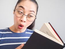 Nerd Asian Woman Got A Surprised Idea From The Book. Royalty Free Stock Images Nerd Asian Woman Got A Surprised Idea From The Book. Royalty Free Stock Images