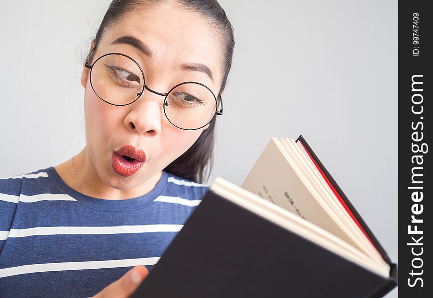Nerd Asian woman got a surprised idea from the book.