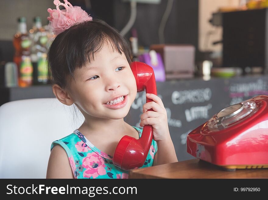 Girl Smiling While Talking With Her Friend By Red Classic Phone