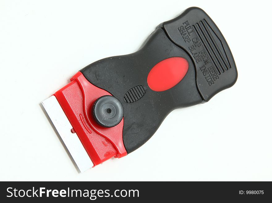 Red and black box cutter with blade.