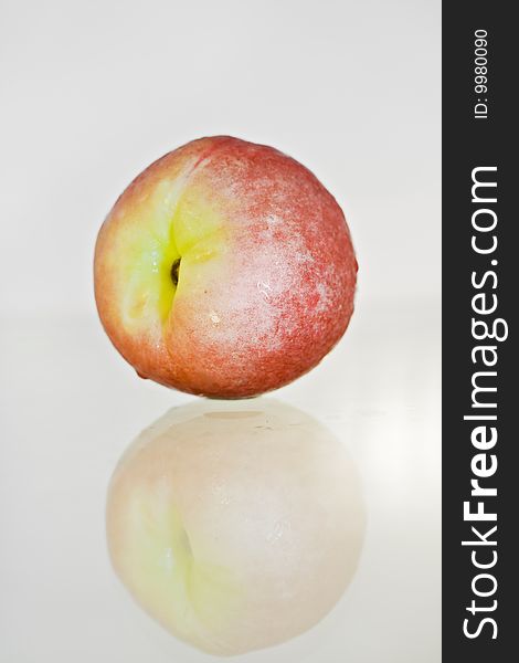 Delicious fresh peach closeup isolated and reflected. Delicious fresh peach closeup isolated and reflected
