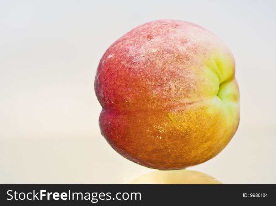 Delicious fresh peach closeup isolated and reflected. Delicious fresh peach closeup isolated and reflected