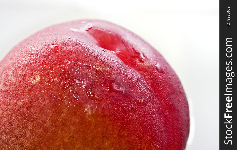 Close up shot of a red healthy peach with water drops against white background. Close up shot of a red healthy peach with water drops against white background