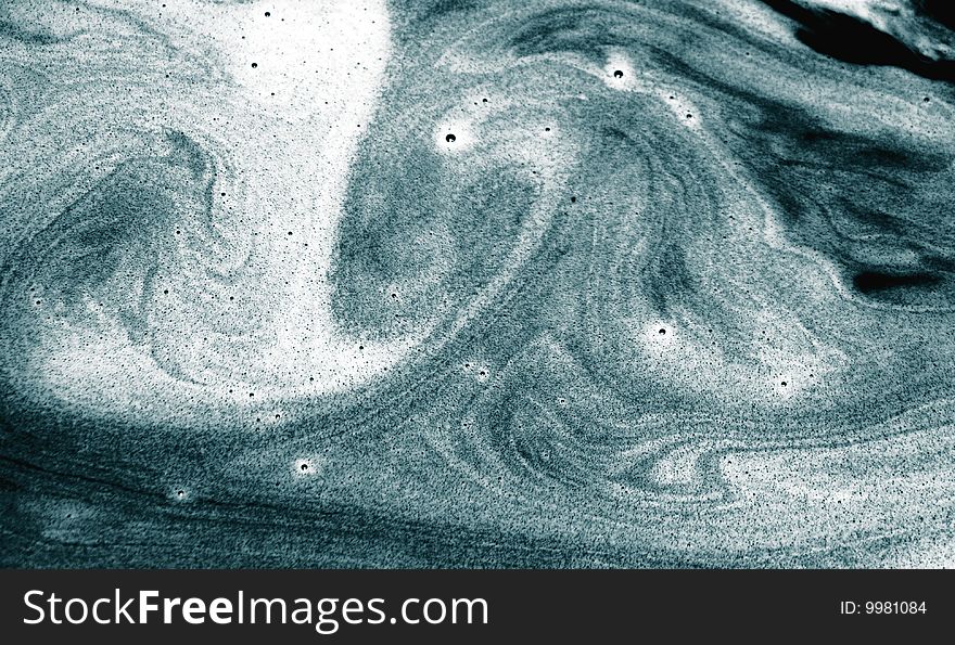 Blue textured abstract patterns created by sand in swirling water. Blue textured abstract patterns created by sand in swirling water.