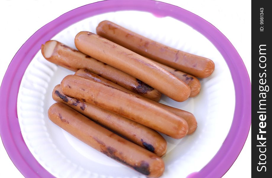 Grilled hot dogs on paper plate isolated on white background