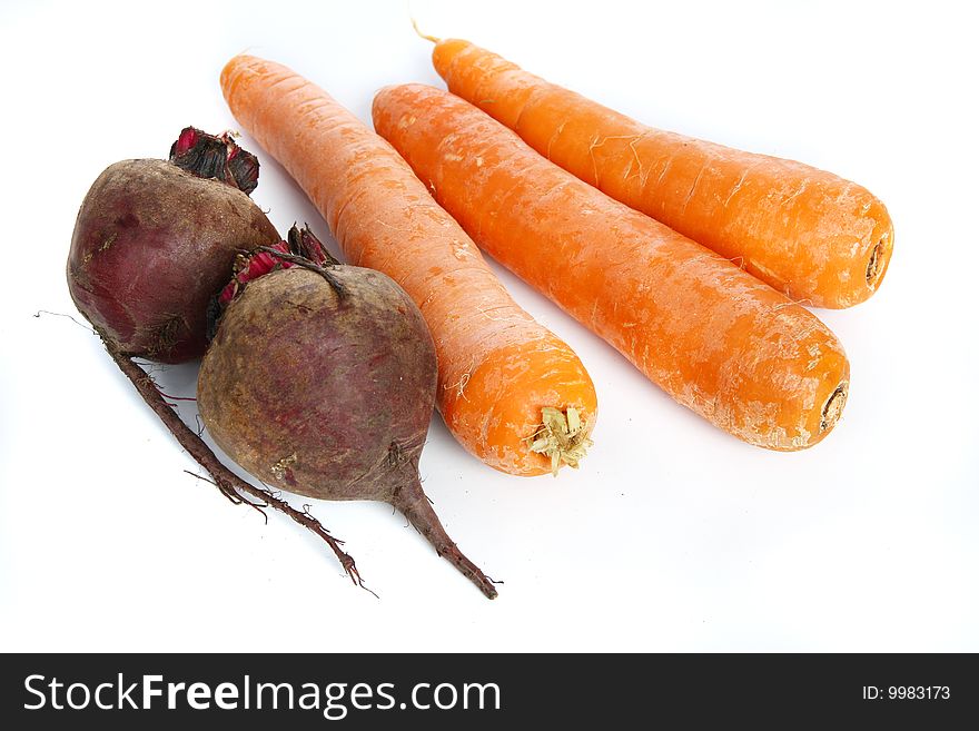 Three big  fresh carrots and two  beets on the  table. Three big  fresh carrots and two  beets on the  table