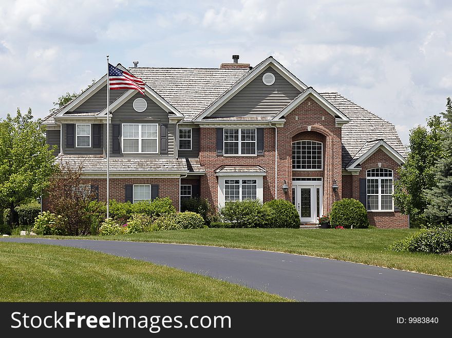 Luxury brick home in suburbs with American flag