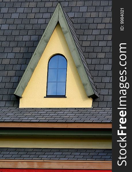 Small window on a roof of cape cord style home. Small window on a roof of cape cord style home