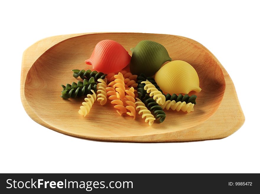 Wooden plate with different particular pasta kinds of yellow, green, red, orange and brown colors. Wooden plate with different particular pasta kinds of yellow, green, red, orange and brown colors