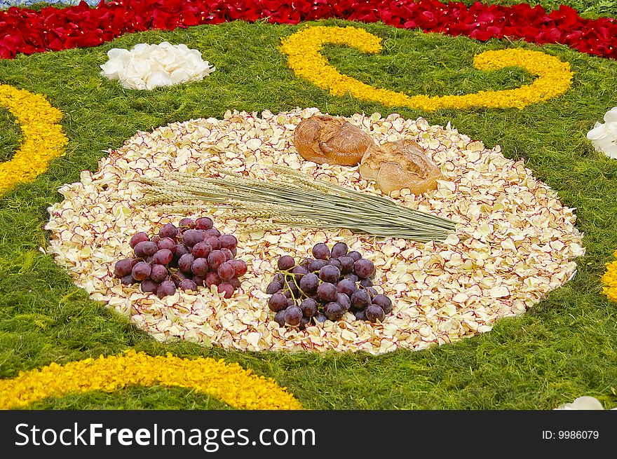 Grapes, bread, corn on a bed of petals. Grapes, bread, corn on a bed of petals