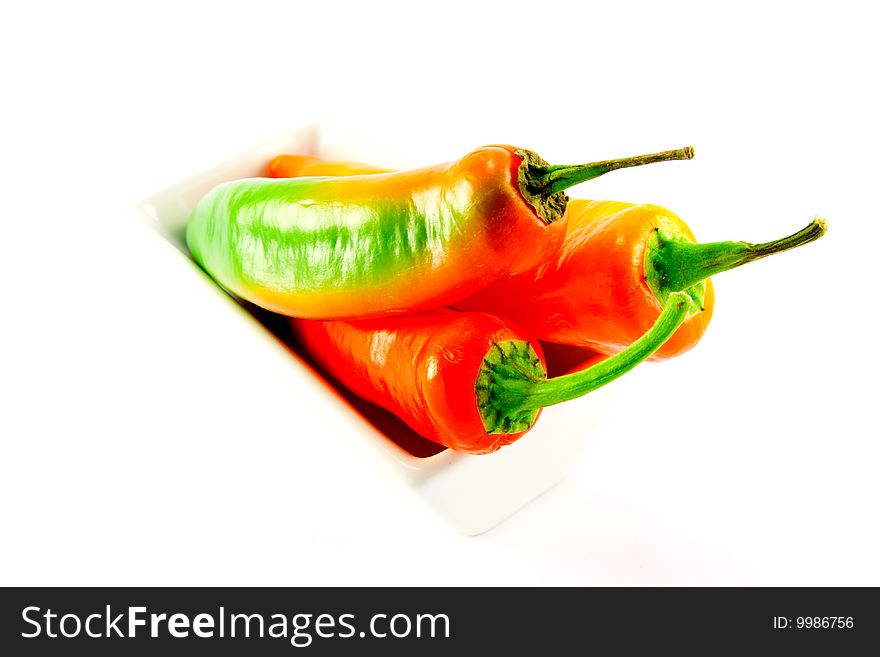 Assorted whole chillis in a square bowl with clipping path on a white background. Assorted whole chillis in a square bowl with clipping path on a white background