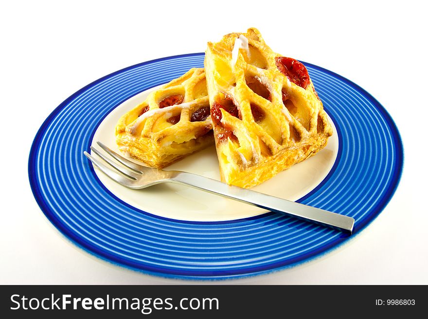 Raspberry and custard danish on a blue and white plate with a fork on a white background. Raspberry and custard danish on a blue and white plate with a fork on a white background