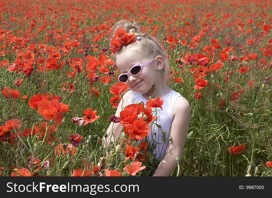On the image there is a little girl. She is in  field of poppys. On the image there is a little girl. She is in  field of poppys.